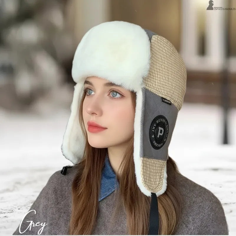 Ouchanka femme portée en extérieur hivernal, chapka en matière polaire avec cache-oreilles couvrants et forme enveloppante, vue de profil sur décor enneigé - Espace Cagoules