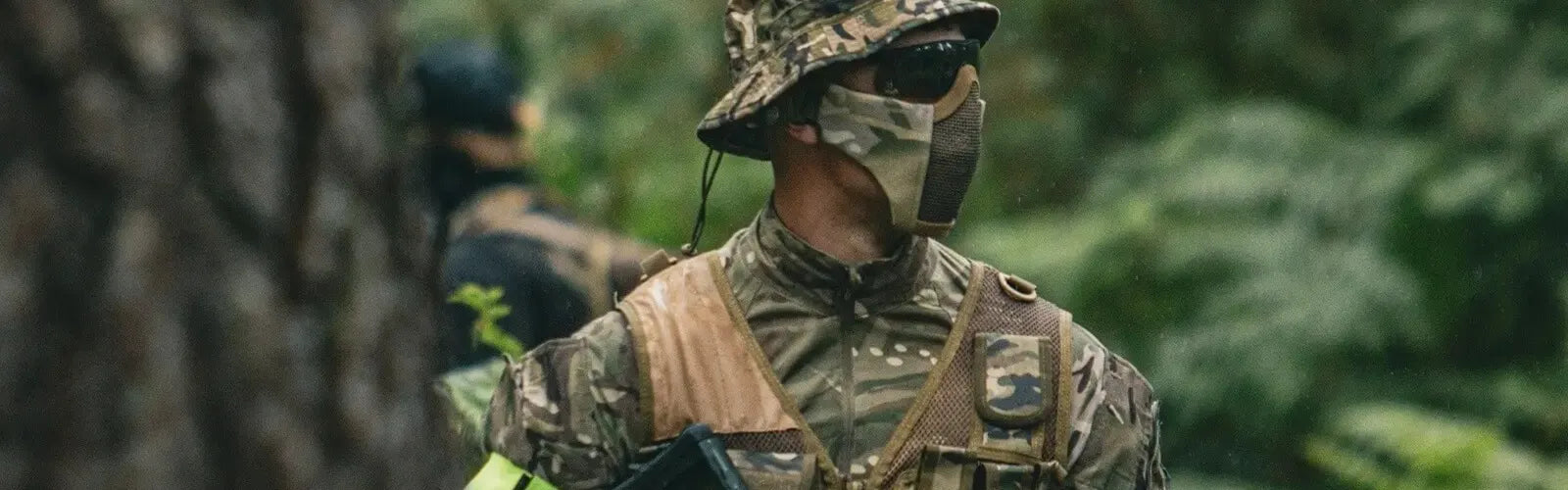 Joueur d’airsoft équipé d’une cagoule camouflage et tenue tactique militaire dans une forêt – Collection Cagoules Airsoft Espace Cagoules