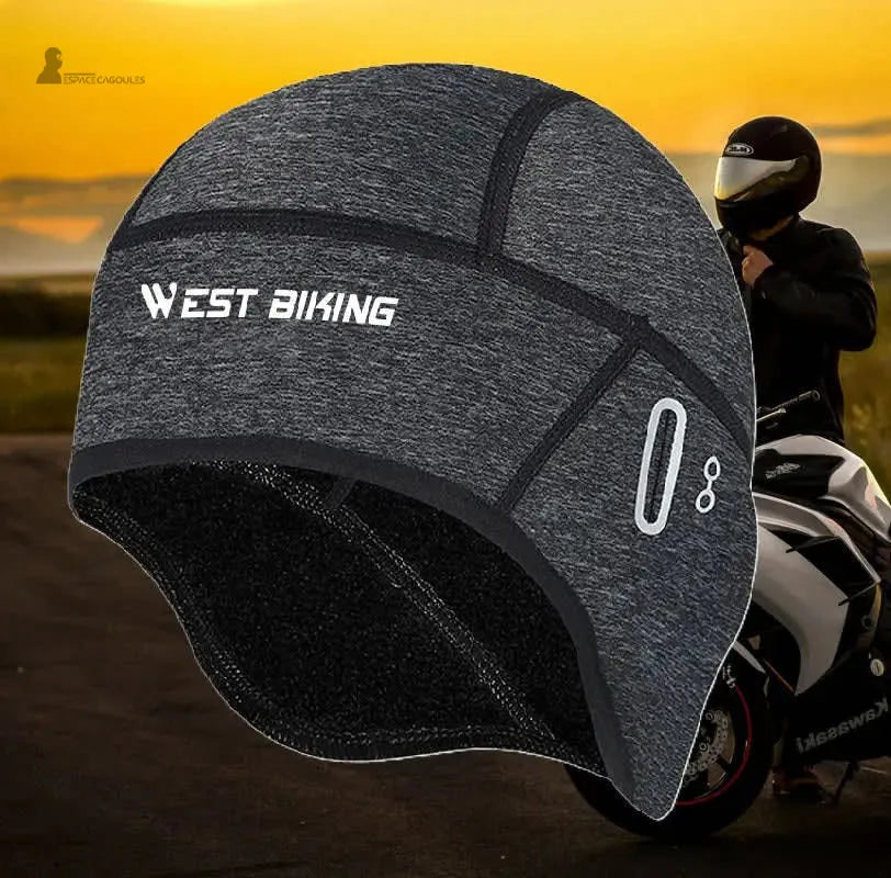 Sous casque moto hiver noir avec doublure polaire et éléments réfléchissants présenté devant un motard - Espace Cagoules