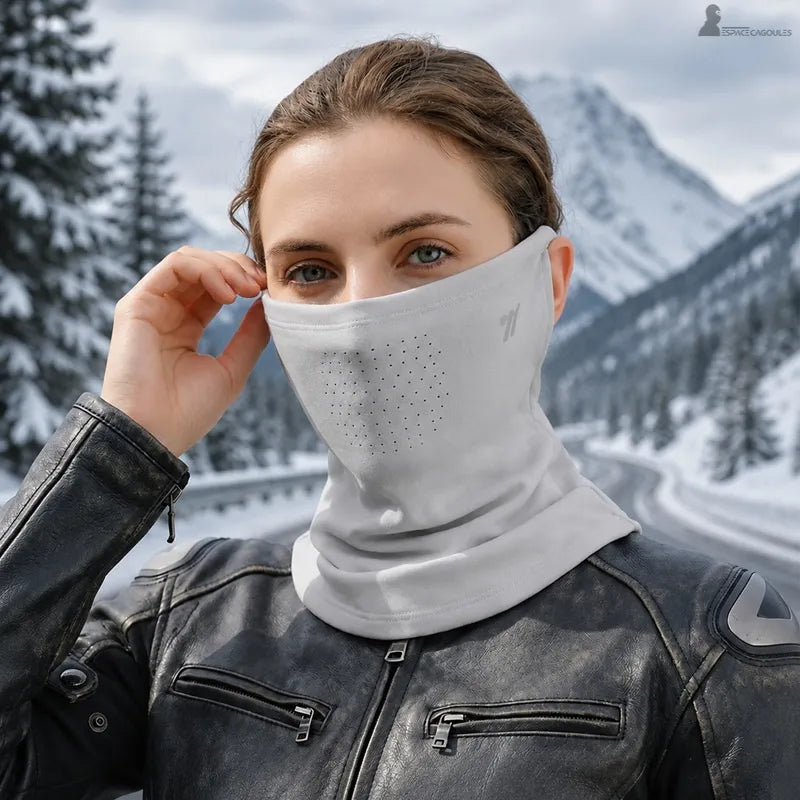 Motarde en blouson cuir portant le tour de cou gris clair sur une route de montagne enneigée - Espace Cagoules